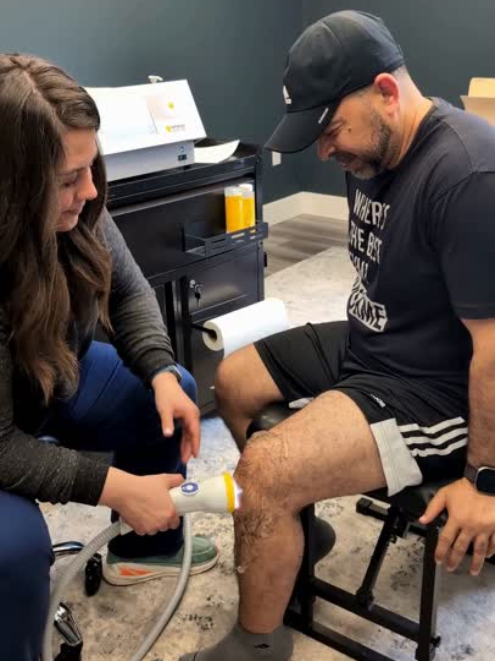 Dr. Faith Swartzendruber administering SoftWave therapy to a patient's knee.