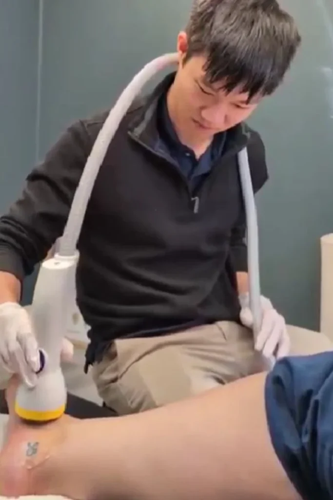 Patient getting ankle sprain treatment in Cincinnati with Softwave Therapy at Simply Well Chiropractic.